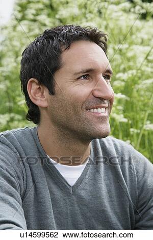 Stock Image - Man smiling, outdoors, close-up, portrait. Fotosearch