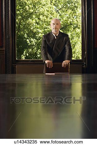 Man Standing at Head of Conference Table, greenery behind View Large Photo Image Stock Photography - Man Standing at Head of Conference Table, greenery behind. Fotosearch