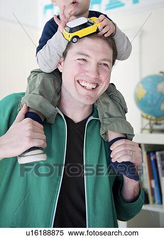 Man stands with his son on his shoulders View Large Photo Image Stock Photography - Man stands with his son on his shoulders. Fotosearch