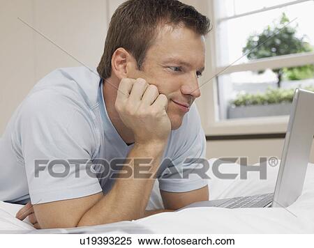 Man Using Laptop on Bed View Large Photo Image Stock Photography - Man Using Laptop on Bed. Fotosearch
