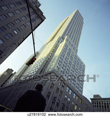 Stock Image - Man Walking by Empire State Building. Fotosearch