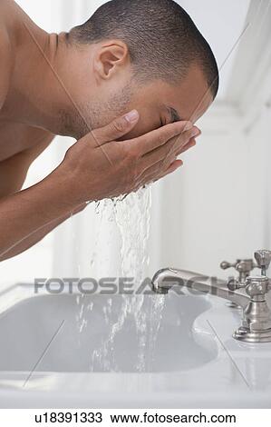 Man washing face in bathroom sink View Large Photo Image Stock Image - Man washing face in bathroom sink. Fotosearch