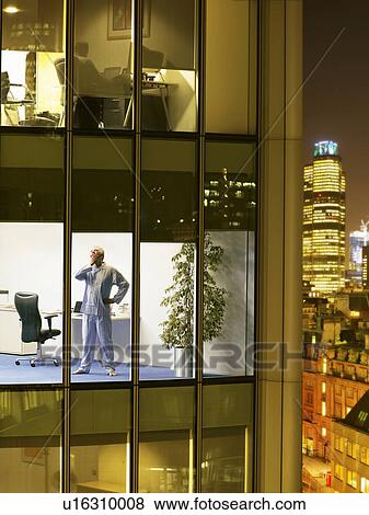 Man wearing pajamas standing in office and yawning, view from building exterior View Large Photo Image Stock Photo - Man wearing pajamas standing in office and yawning, view from building exterior. Fotosearch