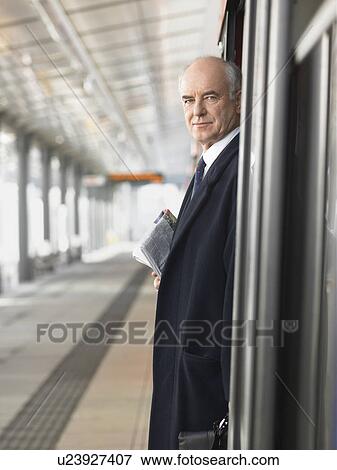 Mature Businessman standing, Waiting at empty Train Station, side view View Large Photo Image Stock Photo - Mature Businessman standing, Waiting at empty Train Station, side view. Fotosearch
