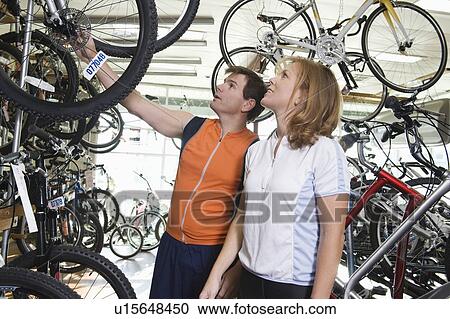 Stock Image - Mature couple choose a new bike. Fotosearch