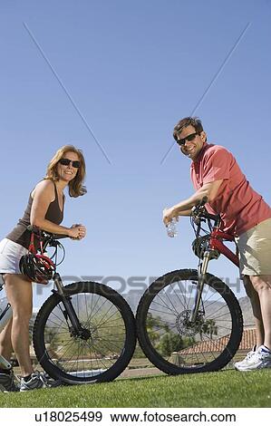 Stock Photo - Mature couple on cycling holiday, face to face. Fotosearch