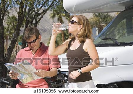 Stock Photograph - Mature couple on cycling holiday with recreational vehicle. Fotosearch