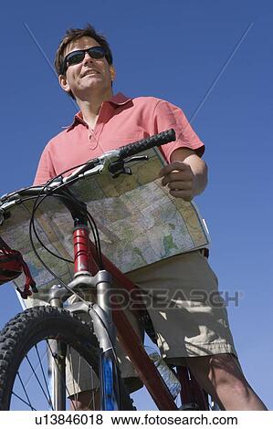 Mature man stands looking at map with mountain bike View Large Photo Image Stock Photo - Mature man stands looking at map with mountain bike. Fotosearch