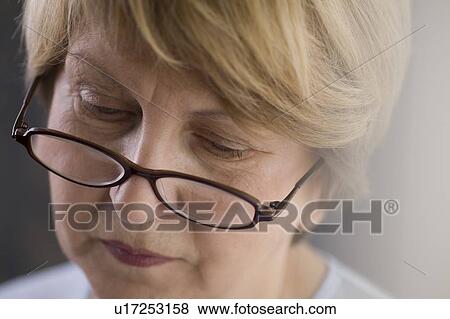 Stock Photo - Mature woman in reading glasses. Fotosearch