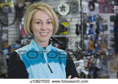 Mature woman stands in bike shop View Large Photo Image Stock Image - Mature woman stands in bike shop. Fotosearch
