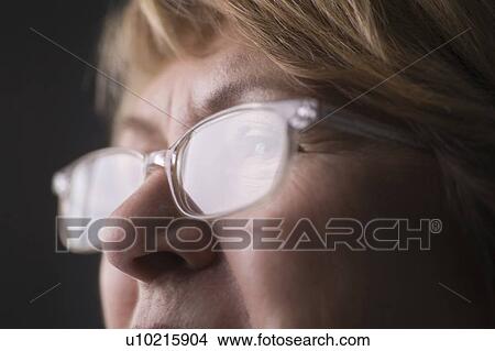 Mature woman with light reflecting on reading glasses View Large Photo Image Picture - Mature woman with light reflecting on reading glasses. Fotosearch