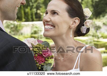 Mid adult bride and groom in garden, smiling, close-up View Large Photo Image Stock Image - Mid adult bride and groom in garden, smiling, close-up. Fotosearch
