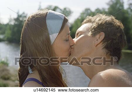 Mid-adult Couple Kissing outdoors, side view View Large Photo Image Stock Photography - Mid-adult Couple Kissing outdoors, side view. Fotosearch