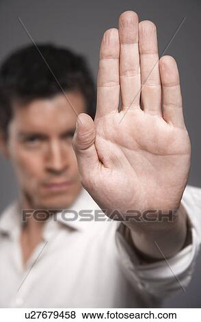 Mid-adult man holding up hand, focus on hand View Large Photo Image Stock Photo - Mid-adult man holding up hand, focus on hand. Fotosearch