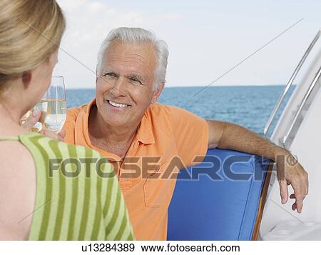 Middle-aged couple drinking wine on yacht View Large Photo Image Stock Photo - Middle-aged couple drinking wine on yacht. Fotosearch