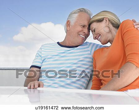 Middle-aged couple outdoors, embracing and smiling View Large Photo Image Stock Image - Middle-aged couple outdoors, embracing and smiling. Fotosearch