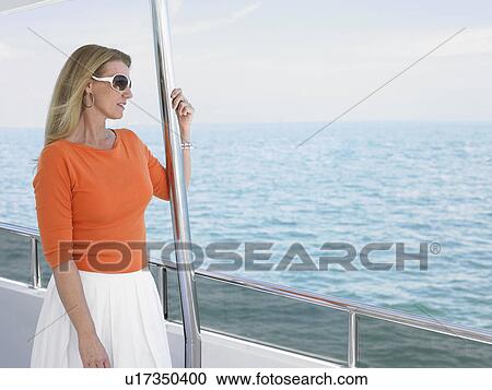 Stock Image - Middle-aged woman on yacht. Fotosearch