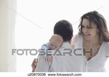 Stock Photograph - Mother and father with newborn baby. Fotosearch