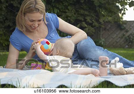 Mother and with baby lying on lawn in garden View Large Photo Image Stock Photograph - Mother and with baby lying on lawn in garden. Fotosearch