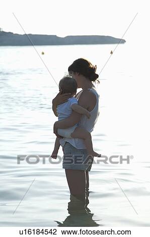 Mother holding son in knee-length water View Large Photo Image Stock Image - Mother holding son in knee-length water. Fotosearch