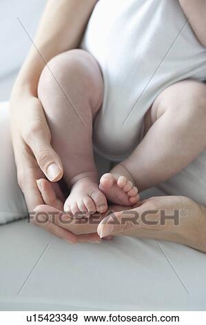 Stock Photo - Mother holds baby boys feet. Fotosearch