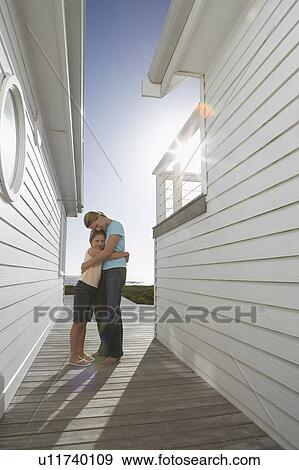 Mother hugging daughter in passageway between houses, full length View Large Photo Image Stock Photo - Mother hugging daughter in passageway between houses, full length. Fotosearch
