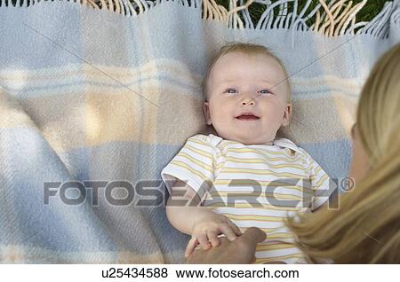 Mother leaning over baby on rug, view from above View Large Photo Image Stock Photo - Mother leaning over baby on rug, view from above. Fotosearch