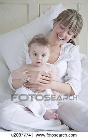 Mother sits holding a baby boy View Large Photo Image Stock Image - Mother sits holding a baby boy. Fotosearch