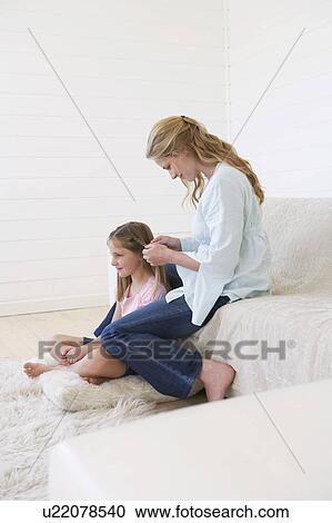 Mother sitting on couch, plaiting daughter's hair View Large Photo Image Stock Image - Mother sitting on couch, plaiting daughter's hair. Fotosearch