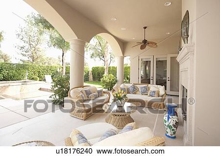 Stock Image - Neutral outdoor room with cane furniture. Fotosearch