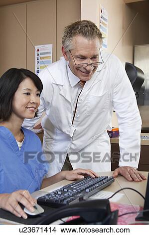 Nurse and doctor working on computer View Large Photo Image Picture - Nurse and doctor working on computer. Fotosearch