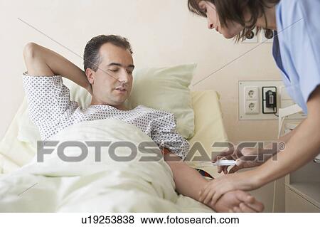 Nurse Giving Patient Injection in hospital bed View Large Photo Image Stock Photo - Nurse Giving Patient Injection in hospital bed. Fotosearch