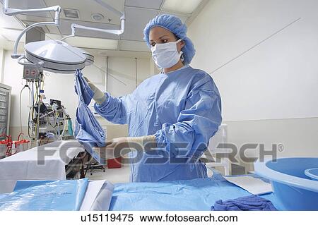 Stock Photography - Nurse preparing bed in operating room. Fotosearch