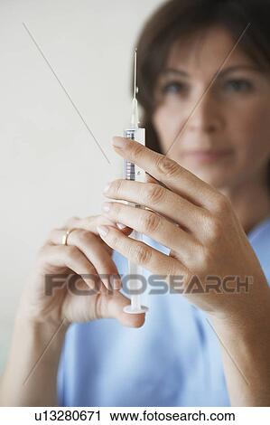Nurse Preparing syringe For Injection, focus on syringe View Large Photo Image Stock Image - Nurse Preparing syringe For Injection, focus on syringe. Fotosearch