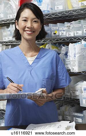 Nurse standing by shelves with medical supplies, portrait View Large Photo Image Stock Image - Nurse standing by shelves with medical supplies, portrait. Fotosearch