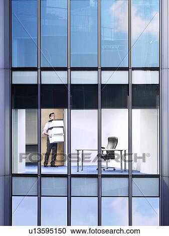 Office worker carrying boxes in office, view from building exterior View Large Photo Image Stock Image - Office worker carrying boxes in office, view from building exterior. Fotosearch