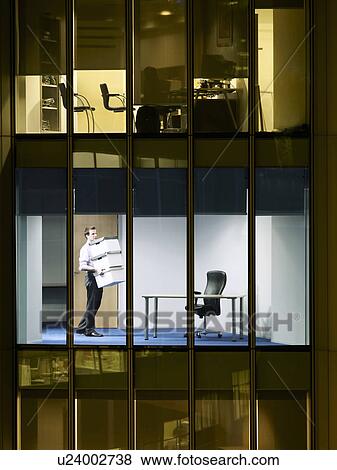 Office worker carrying boxes in office, view from building exterior View Large Photo Image Stock Photo - Office worker carrying boxes in office, view from building exterior. Fotosearch