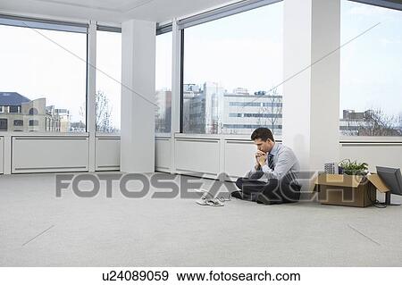 Office worker contemplating phone, sitting on floor of empty office space, side view View Large Photo Image Stock Photo - Office worker contemplating phone, sitting on floor of empty office space, side view. Fotosearch