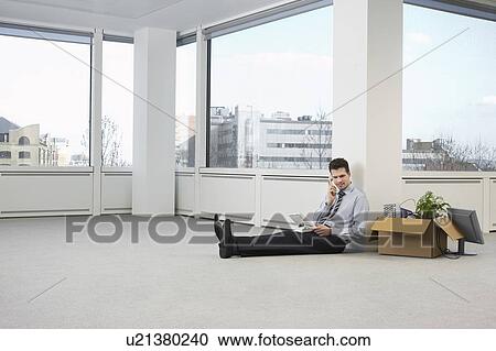 Office worker talking on phone, sitting on floor of empty office space View Large Photo Image Stock Image - Office worker talking on phone, sitting on floor of empty office space. Fotosearch