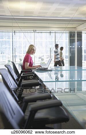 Office worker using laptop, sitting in conference room, side view View Large Photo Image Stock Image - Office worker using laptop, sitting in conference room, side view. Fotosearch