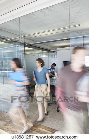 Stock Photo - Office workers leaving conference room, long exposure. Fotosearch