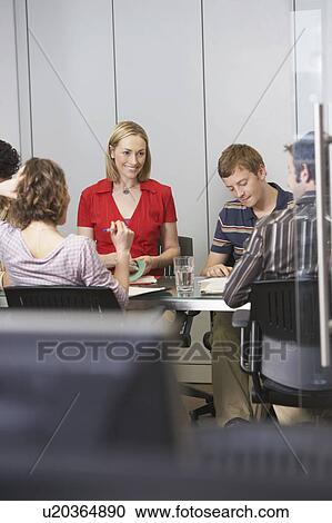 Office workers sitting around conference table View Large Photo Image Stock Image - Office workers sitting around conference table. Fotosearch