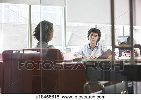 Office workers sitting in office, view through glass wall View Large Photo Image Stock Photo - Office workers sitting in office, view through glass wall. Fotosearch
