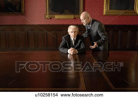 Picture - One Man Talking to Another in boardroom. Fotosearch