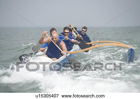 Stock Photo - Outrigger canoeing team on water. Fotosearch