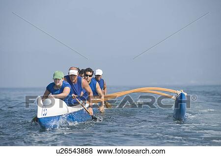 Stock Photo - Outrigger canoeing team on water. Fotosearch