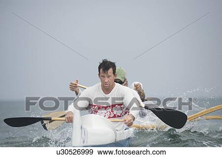 Stock Photo - Outrigger canoeing team on water. Fotosearch