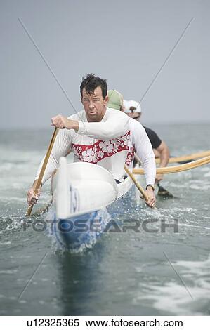 Stock Photography - Outrigger canoeing team on water. Fotosearch