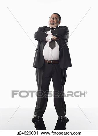Stock Image - Overweight businessman standing with arms folded. Fotosearch