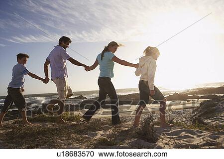 Parents and children walking hand in hand, on seashore, side view View Large Photo Image Stock Image - Parents and children walking hand in hand, on seashore, side view. Fotosearch